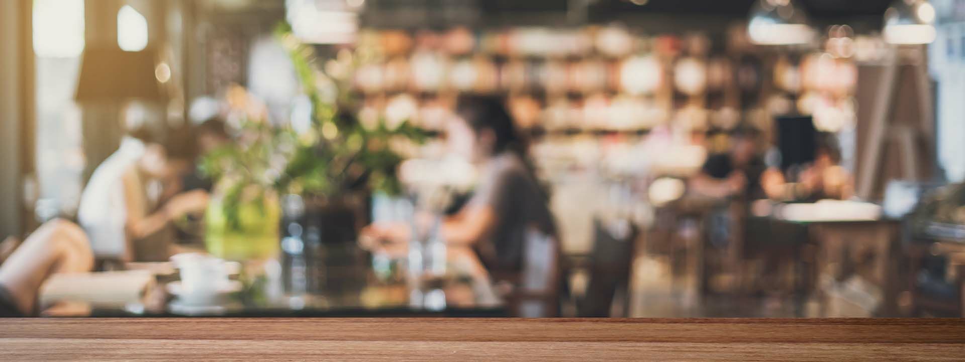 Ein blauer Hintergrund mit einem nur unscharf erkennbaren Innenraum eines Restaurants.