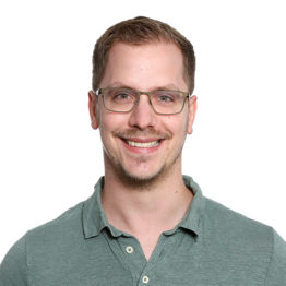 Mann mit Brille und hellbraunen Haaren in grünem Hemd schaut in die Kamera.